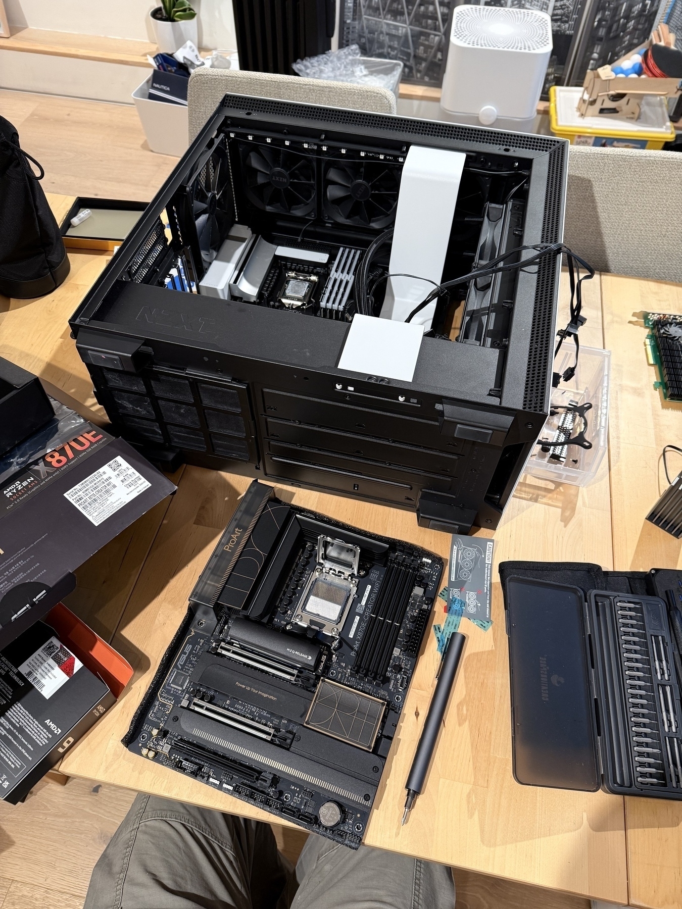 Black ASUS motherboard next to open computer case