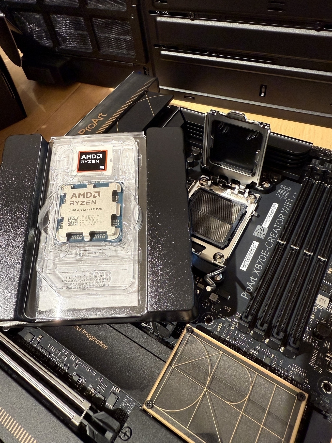 AMD Ryzen 9 9950X3D CPU in packaging, on a black ASUS motherboard